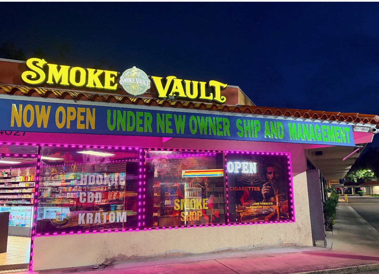 Smoke Vault storefront on Cortez Rd W in Bradenton lit up with neon signage at night